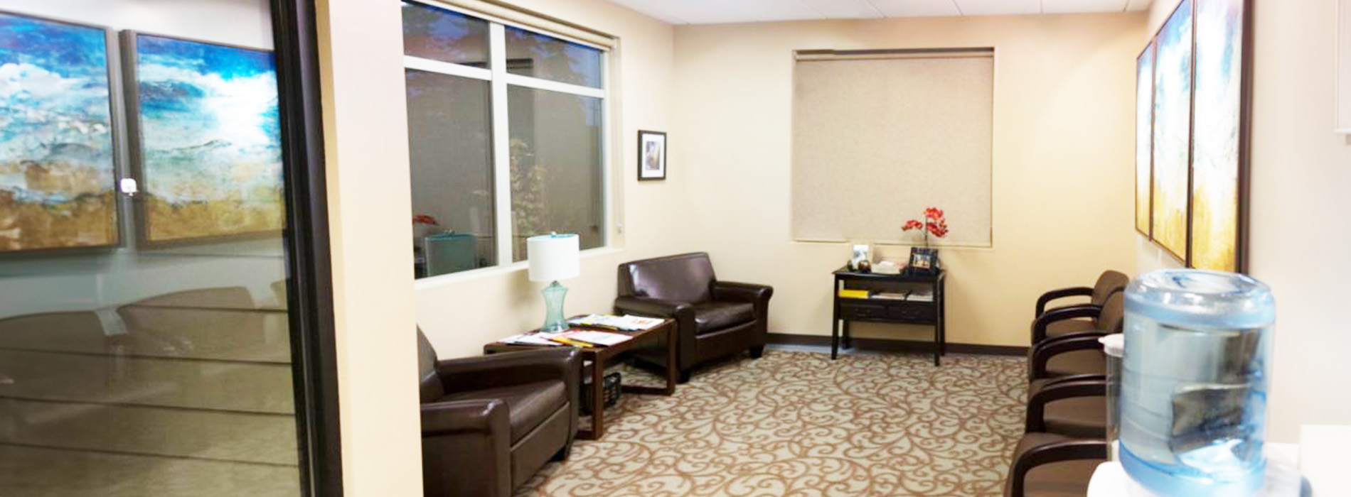 The image shows a modern dental clinic interior with various pieces of equipment, including a dental chair and an X-ray machine.