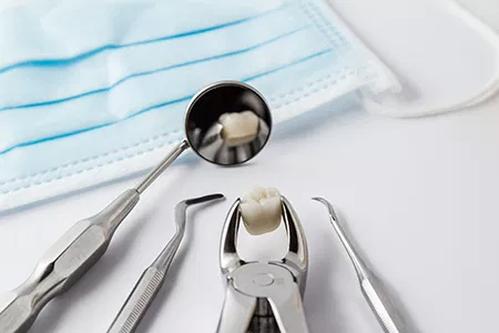 A dental tool set with a toothpick, displayed on a white background near medical equipment.